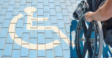 Une personne en fauteuil roulant sur une place réservée aux handicapés