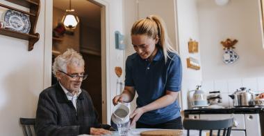 Une jeune femme aide une personne âgée