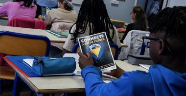 un collégien regarde un dépliant sur le harcèlement scolaire