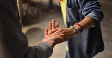 Un enfant tient la main d'une personne âgée