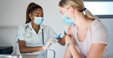 Un médecin vaccine un adulte