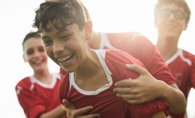Des jeunes portant des maillots de foot en train de chahuter