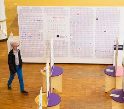 Un homme visitant une exposition sur le braille