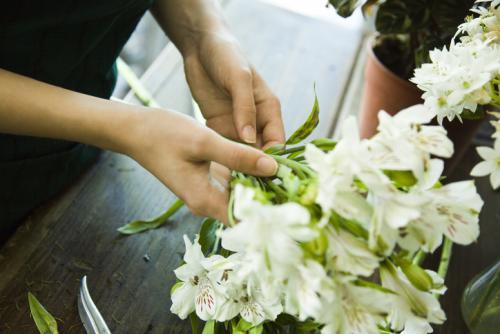 Une fleuriste compose un bouquet de fleurs de lys