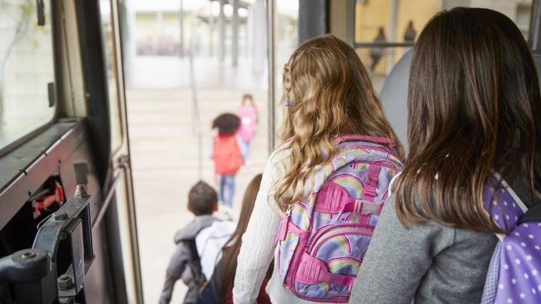 Des enfants descendent d'un bus scolaire