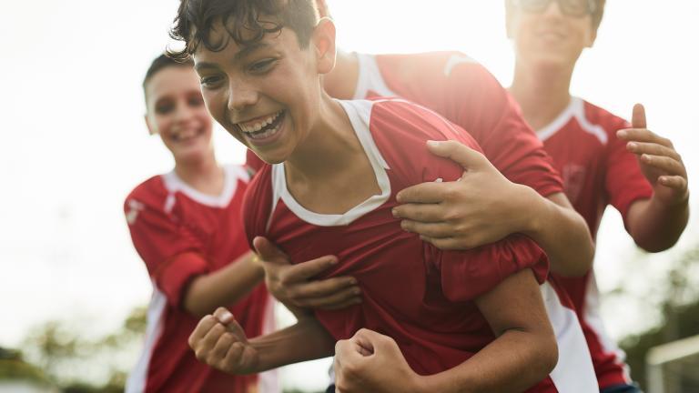 Des jeunes portant des maillots de foot en train de chahuter
