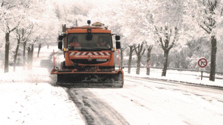 Camion de déneigement sur route enneigée