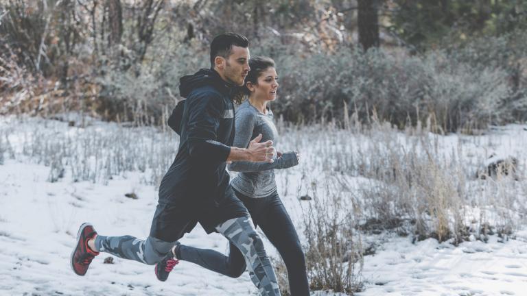 Une femme et un homme courent dans la neige